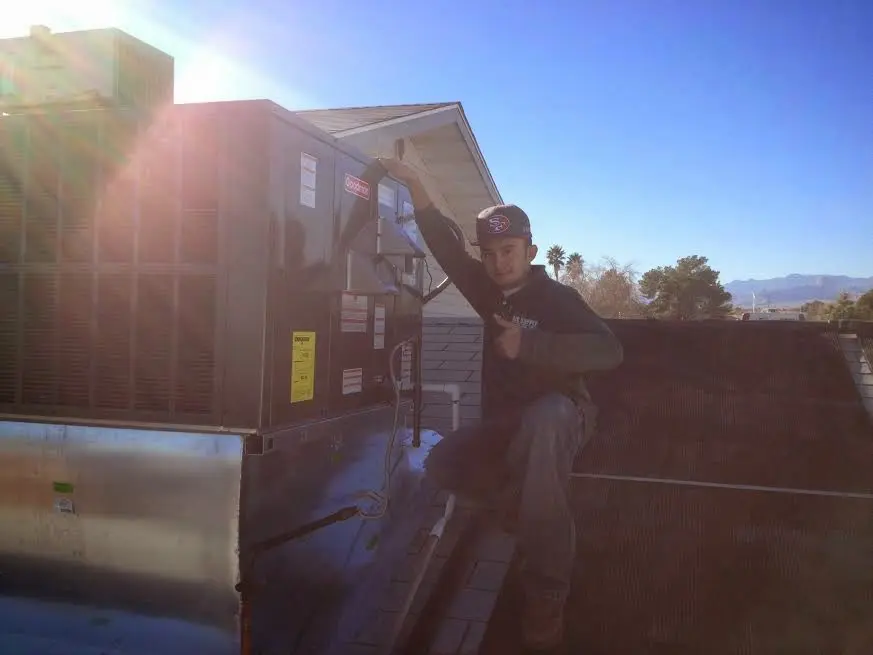 HVAC technician performing Air Duct Repair on a rooftop unit in Unity